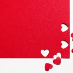 Red paper with cut-out hearts symbolizing love, romance, and sacred marriage